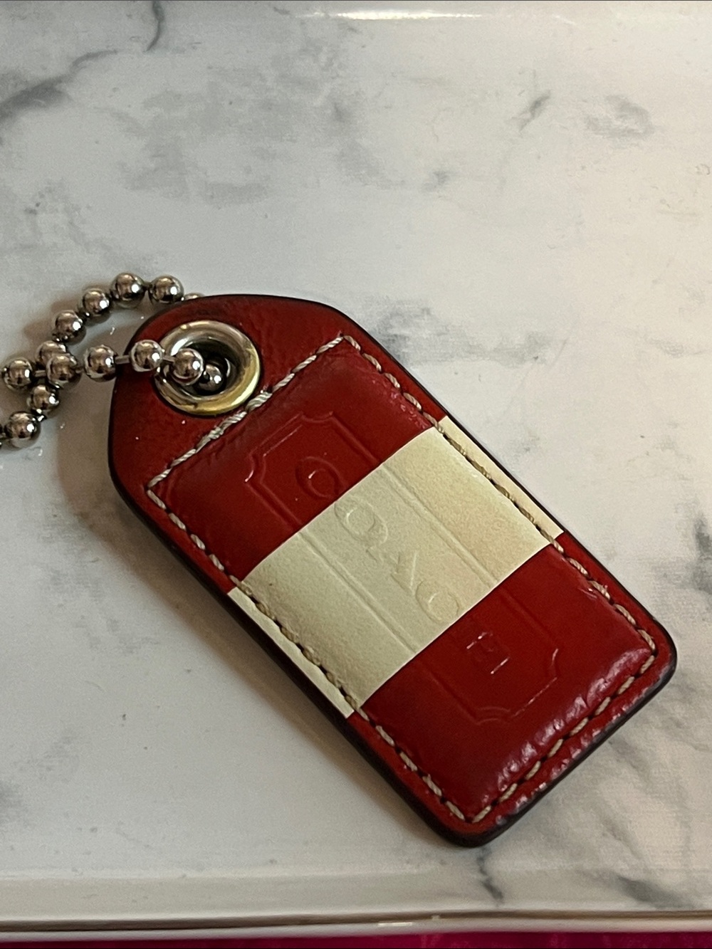Coach Red and Cream Leather hangtag with ball chain. Preowned condition.